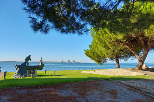 Statue of a fisherman in front of the sea.