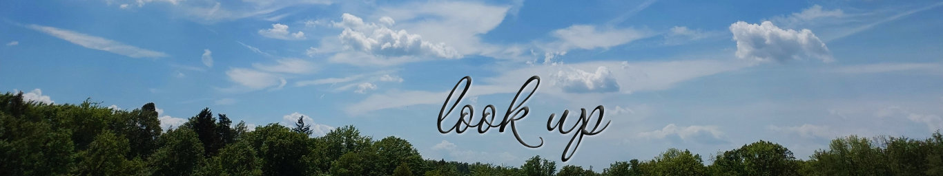 A tree line at the bottom. Most of the image shows a bright blue sky with white clouds. 
      The writing in the centre reads: look up.