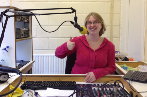 A picture of me sitting in the studio of University Radio Falmer, giving the camera a thumbs up.