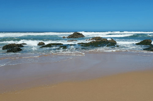 A sand beach with a lot of waves.